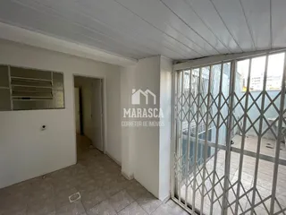 Interior de um corredor com piso de cerâmica claro.