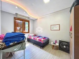 Quarto com cama e janela de madeira em um imóvel no Brasil.
