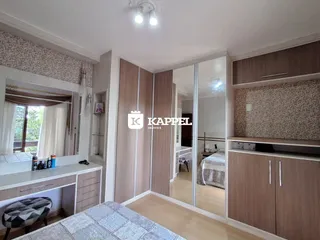 Quarto com armário embutido e janela com cortina.