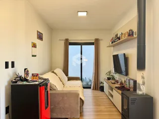 A sala de estar apresenta um sofá e piso de madeira.