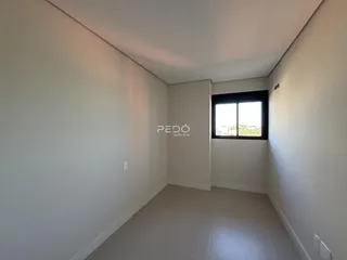 Vista interna de um ambiente com paredes brancas e piso claro.