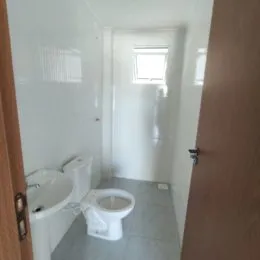 Foto interna de um banheiro com vaso sanitário branco.