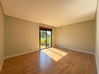 Sala de estar ampla com piso de madeira clara.