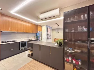 Vista da cozinha moderna com armários de madeira e piso claro.