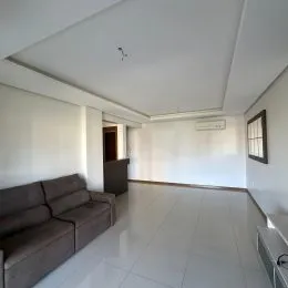 Sala de estar clara com sofá e piso de porcelanato.