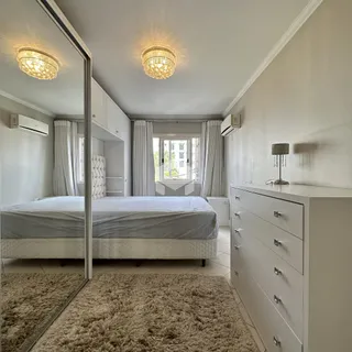 Quarto com cama, armários embutidos e piso de cerâmica.