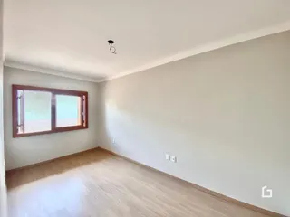 Imagem de um ambiente interno com piso de madeira e janela.