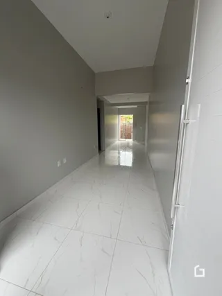 Foto de um corredor interno de uma residência com piso de mármore claro.