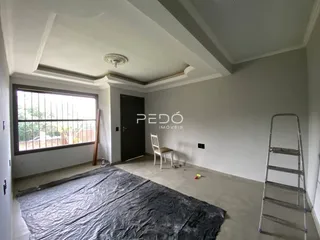Interior de uma sala com janela e porta em uma residência.