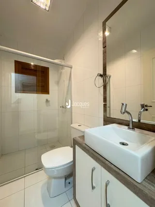 Banheiro com piso cerâmico e revestimento branco.
