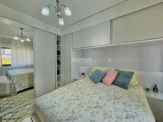 Quarto com cama e armários em um ambiente claro.