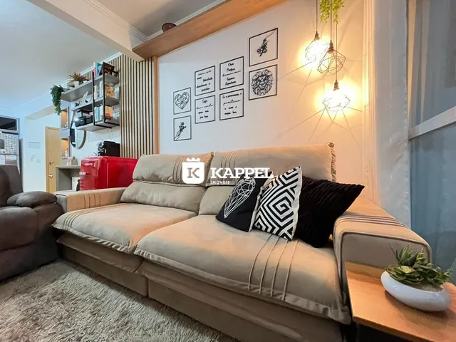 Sala de estar com sofá grande e decoração moderna em ambiente interno.