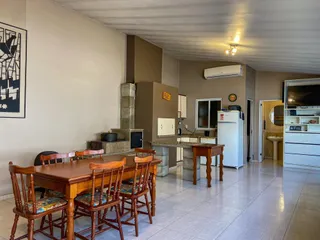Sala de jantar com mesa de madeira e lareira em um imóvel.