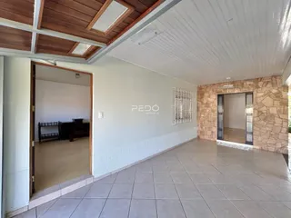 Vista de um ambiente interno com piso de cerâmica e parede de pedra no imóvel.