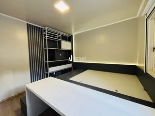 Foto de um interior de quarto com parede de destaque e estante.