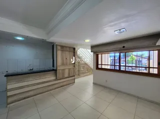 Ambiente interno de uma sala com piso de cerâmica e grandes janelas.