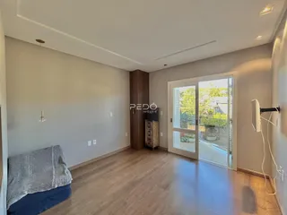 Sala de estar com piso de madeira e porta de vidro abrindo para o exterior.