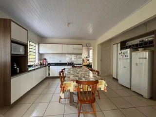 Vista interna de uma sala de jantar com cozinha em um imóvel no Brasil.