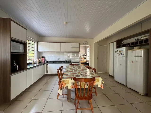 Vista interna de uma sala de jantar com cozinha em um imóvel no Brasil.