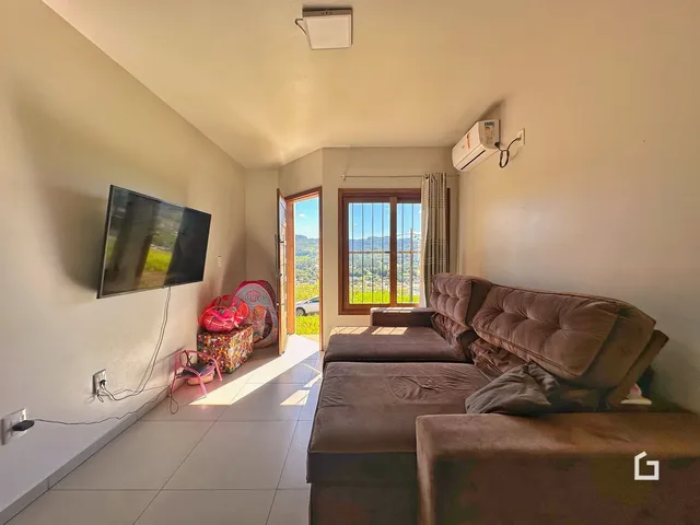 Sala de estar com sofá e televisão em um imóvel no Brasil.