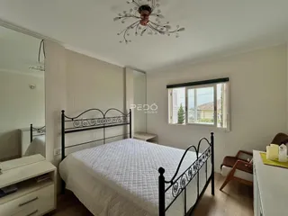 Quarto com cama de ferro forjada e janela no ambiente.