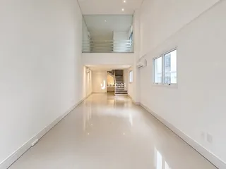 Corredor longo e iluminado de um apartamento moderno.