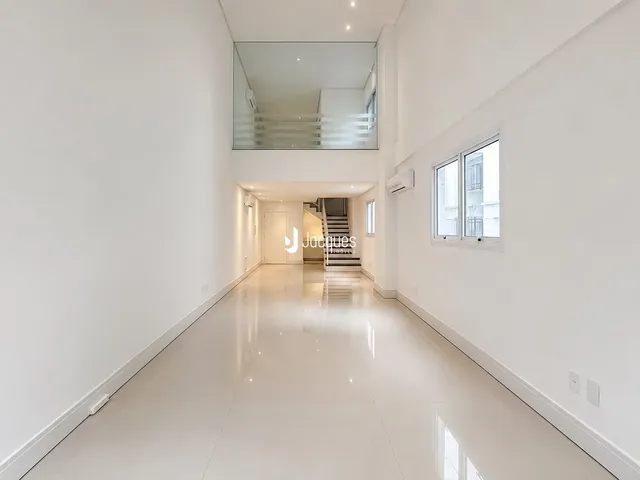 Corredor longo e iluminado de um apartamento moderno.