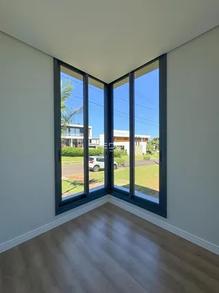 Vista da sala de estar com grandes janelas que dão para o quintal.