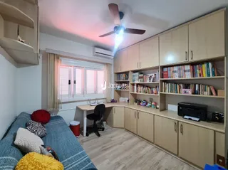 Foto de uma sala de estar com armários e piso de madeira clara.