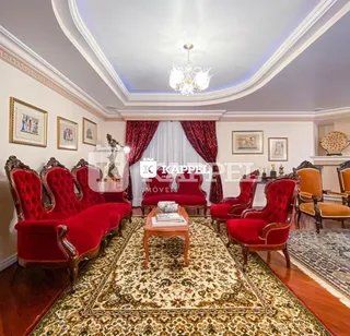Sala de estar com sofás vermelhos e tapetes ornamentados.