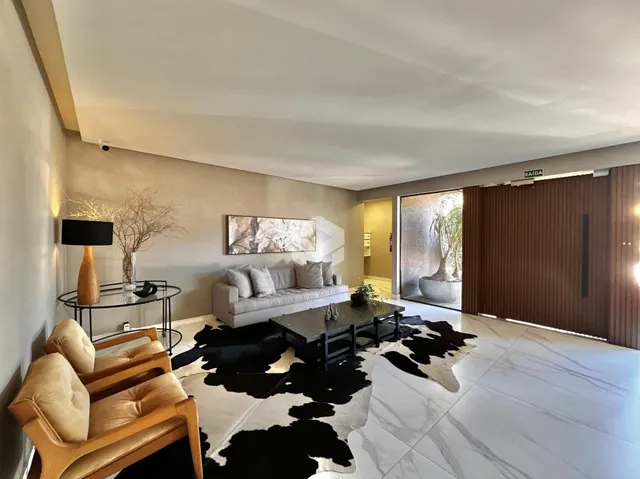 Sala de estar com sofá e decoração clara em um imóvel no Brasil.