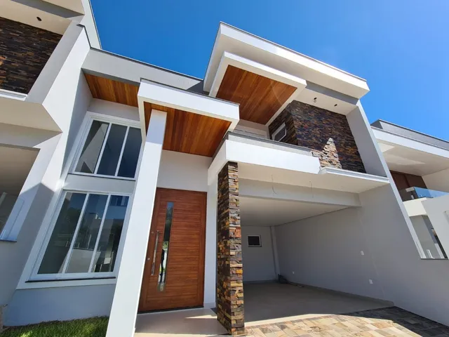 Fachada moderna de uma residência em Lajeado, Brasil, com detalhes em madeira e pedra.
