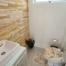 Pia branca em um ambiente interno com parede texturizada.