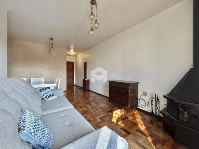 Sala de estar com piso de madeira e sofá cinza.