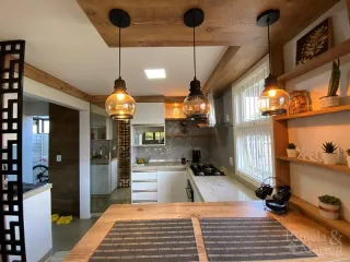 Foto interna de uma cozinha com armários e piso de madeira.