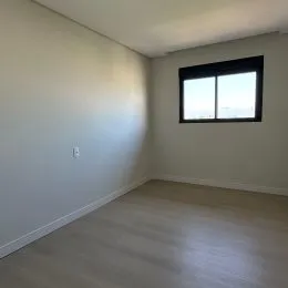 Foto de um cômodo interno vazio com paredes brancas.