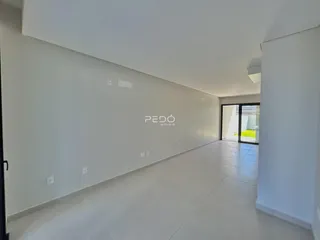 Corredor interno de uma residência com paredes brancas e piso claro.