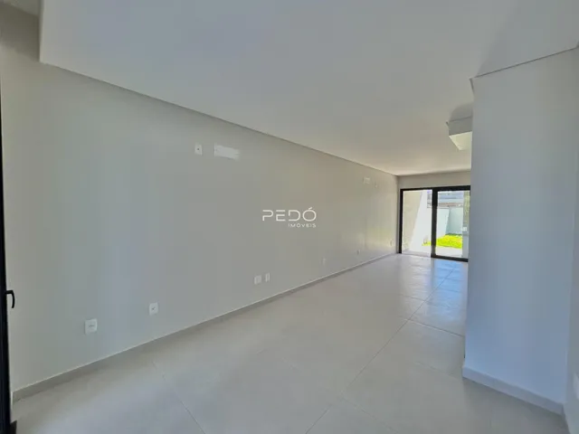 Corredor interno de uma residência com paredes brancas e piso claro.