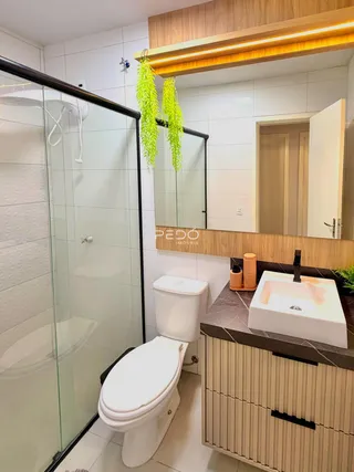 Banheiro com box de vidro e bancada moderna.