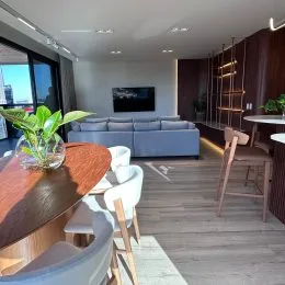 Sala de estar com sofá e piso de madeira clara.
