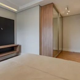 Foto de um quarto com cama e cabeceira em um imóvel.