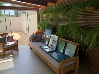 Sala de estar com mobiliário de madeira e plantas.
