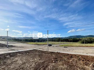 Vista externa de um terreno aberto com paisagem de colinas ao fundo.