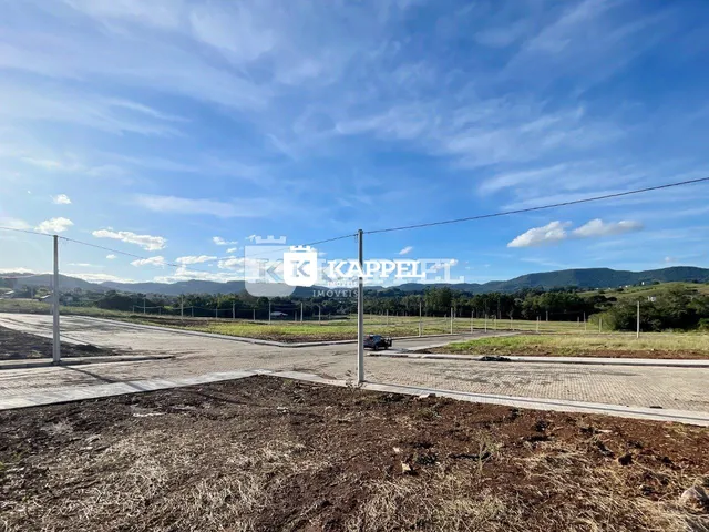 Vista externa de um terreno aberto com paisagem de colinas ao fundo.