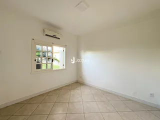 Ambiente interno de uma sala com piso de cerâmica e janela.