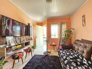 Ambiente interno de uma sala com cama e televisão em Lajeado, Brasil.