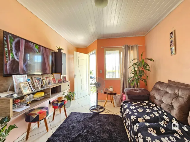 Ambiente interno de uma sala com cama e televisão em Lajeado, Brasil.