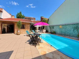 Foto da área externa com piscina e deck de uma residência em Lajeado.
