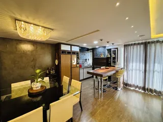 Interior de uma sala de jantar com móveis de madeira e iluminação decorativa.