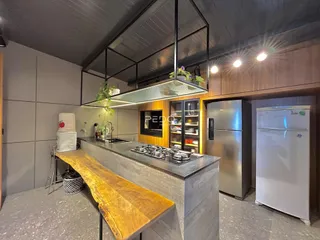 Cozinha moderna com ilha de madeira e eletrodomésticos de aço inoxidável.